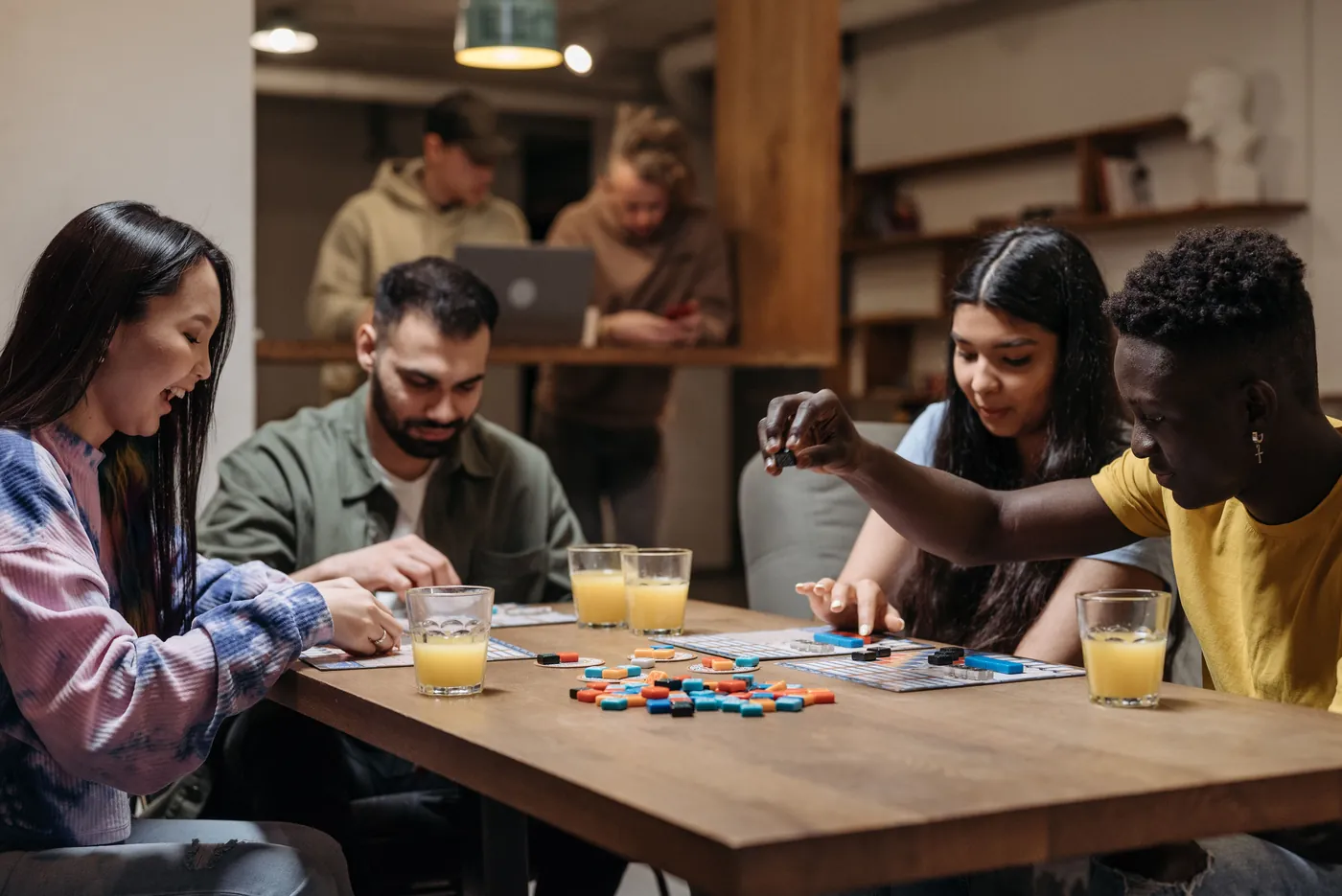 A group of friends laughing and playing a tile game together